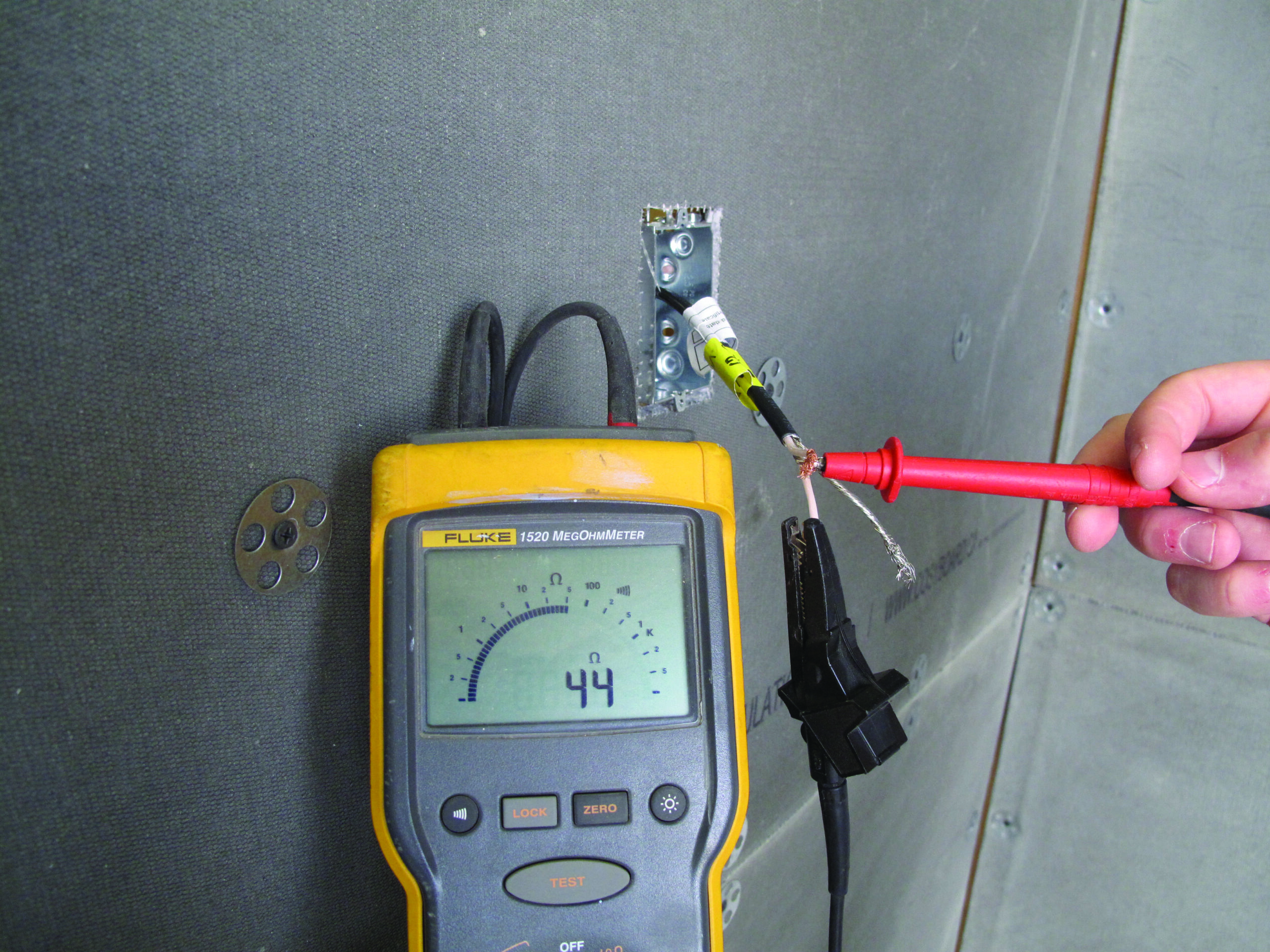 Digital ohm meter measuring resistance during installation
